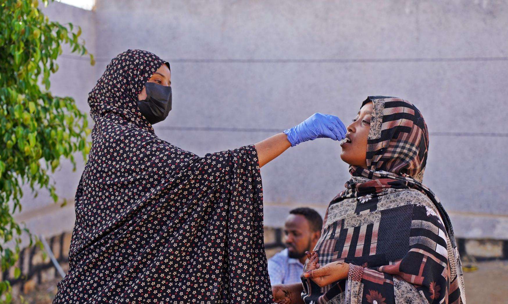 A woman administers a cholera oral vaccine in Ethiopia.
