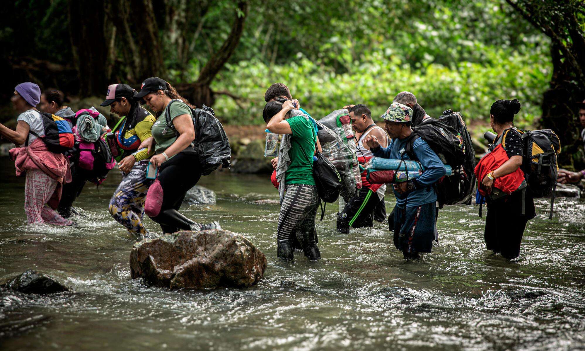 Migrants cross a river in the Darien Gap 
