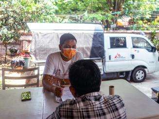 A patient living with HIV and hepatitis C speaks with an MSF health worker in Yangon.