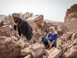 An Afghan man digs through the remains of his house beside his mother after the earthquake in Herat, Afghanistan. 