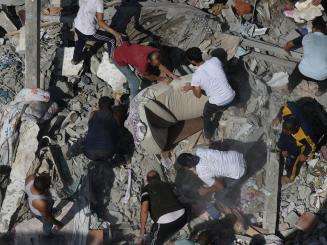 Palestinians search for survivors in the rubble left by an Israeli airstrike on Gaza in October 2023.