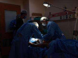 Surgeons operate under a spotlight at Al Aqsa hospital in Gaza.