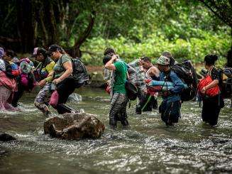 Migrants cross a river in the Darien Gap 