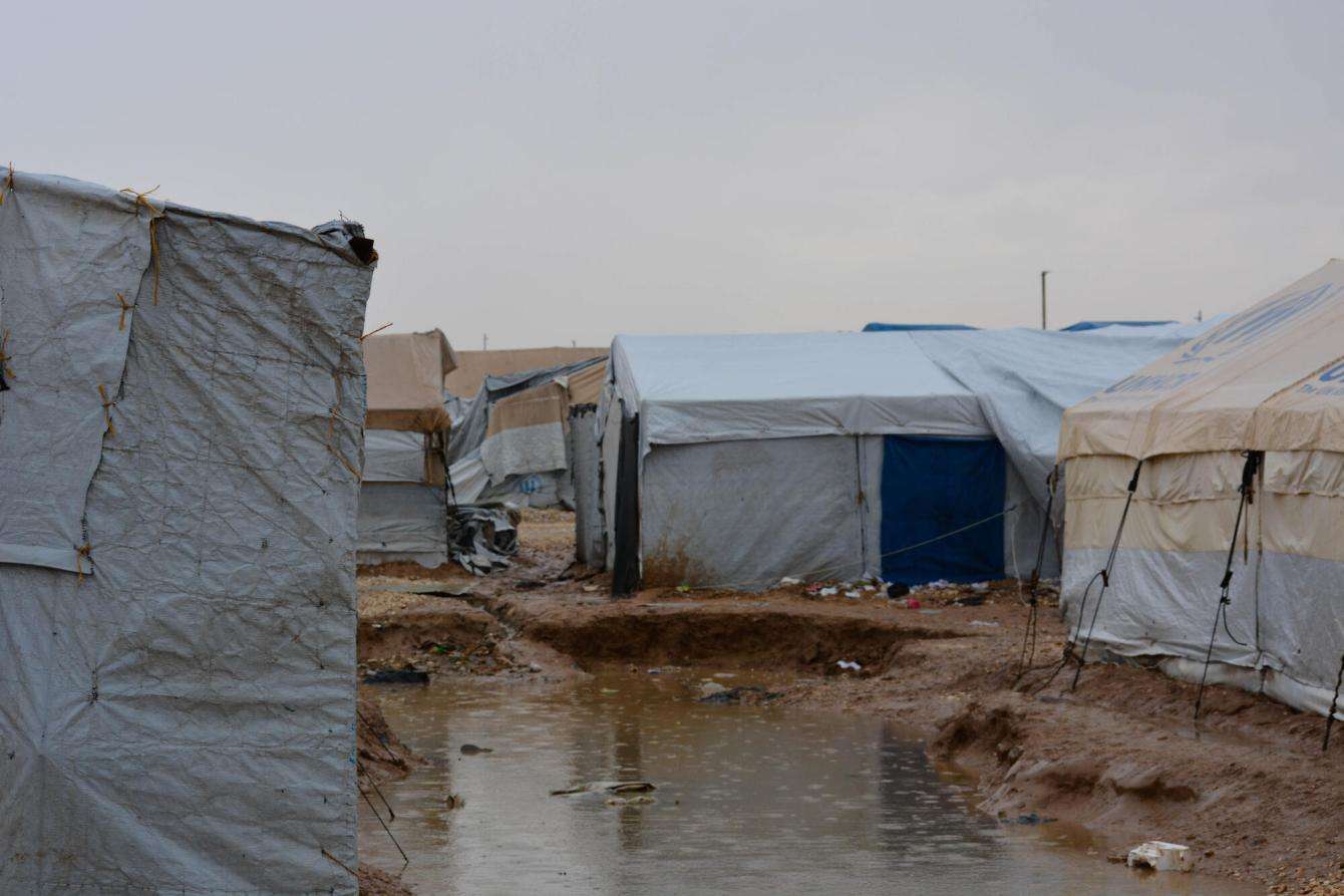 Muddy pools spread across the camp after relentless rain. 