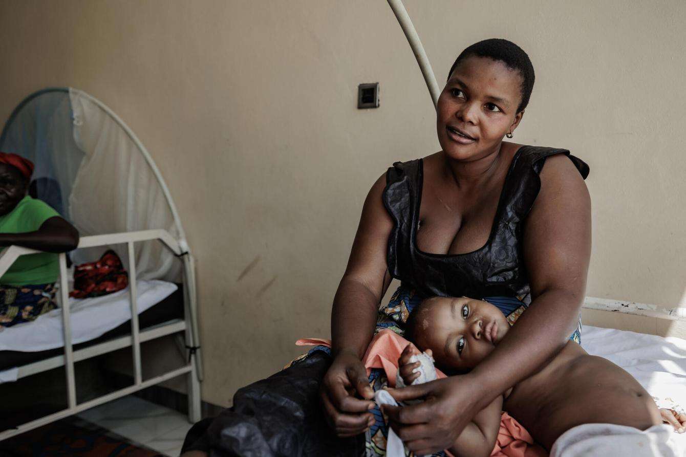 A mother and child sitting on a hospital bed in Salama Hospital in Ituri, DRC.