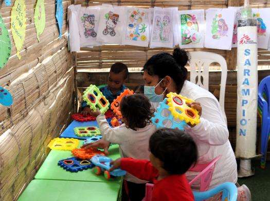 An MSF staff member plays with children at the MSF clinic in Tumbes, Peru.