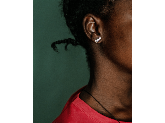 Profile of a woman wearing an earring that says "beauty" in Nigeria.