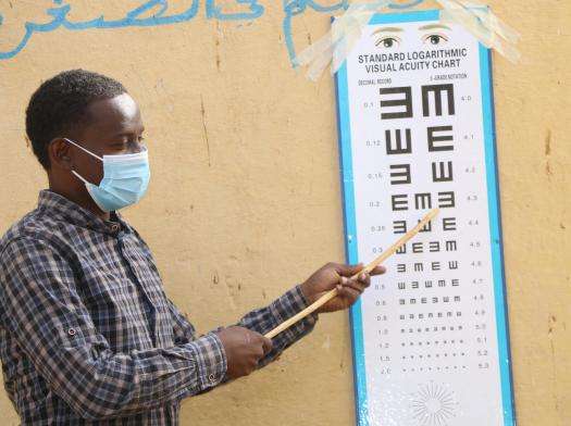 Ophthalmic Nurse Farhan Ali takes a patient through eye chart reading test to determine visual ability during eye exercise in Hudur town, Bakool region.