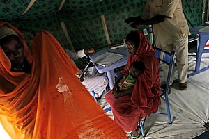 A mother waits for an MSF staff member to examine her child at an MSF clinic in Kebkabiya