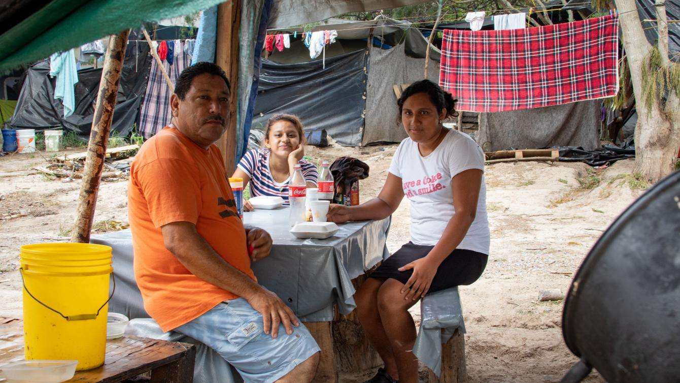 A family seeking asylum eats breakfast in the Matamoros camp
