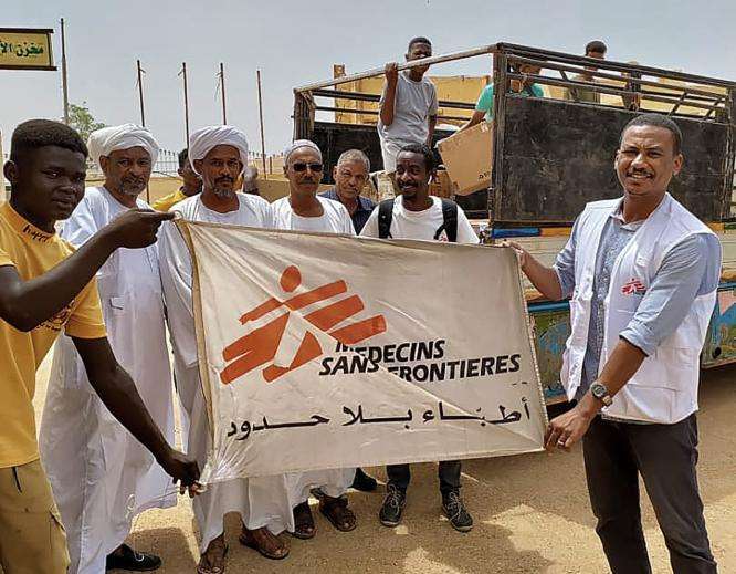 Dr. Mohammad Bashir holds an MSF flag with others in Sudan.