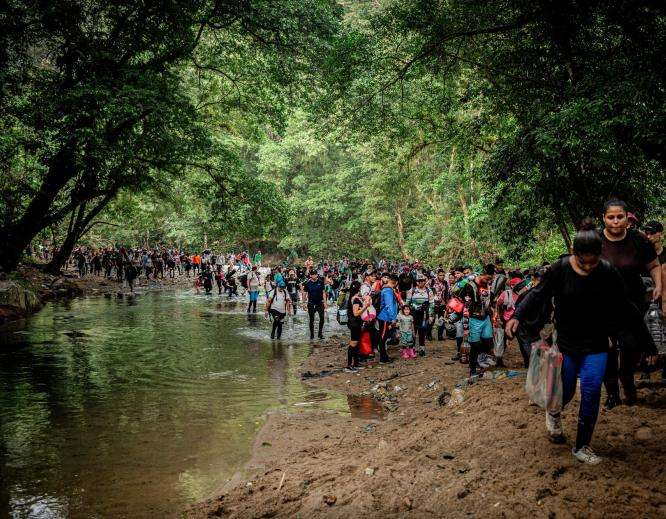 Migrants cross the Acandí and Tuquesa rivers on their way through the jungle of the Darién Gap.