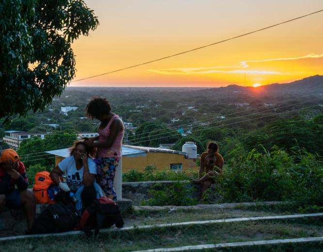 Migrants resting on a hilltop at sunset in Arriaga, Chiapas, Mexico