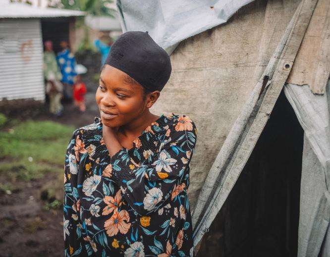 A young woman in front of her makeshift tent in Kanyaruchinya camp for displaced people in DR Congo.