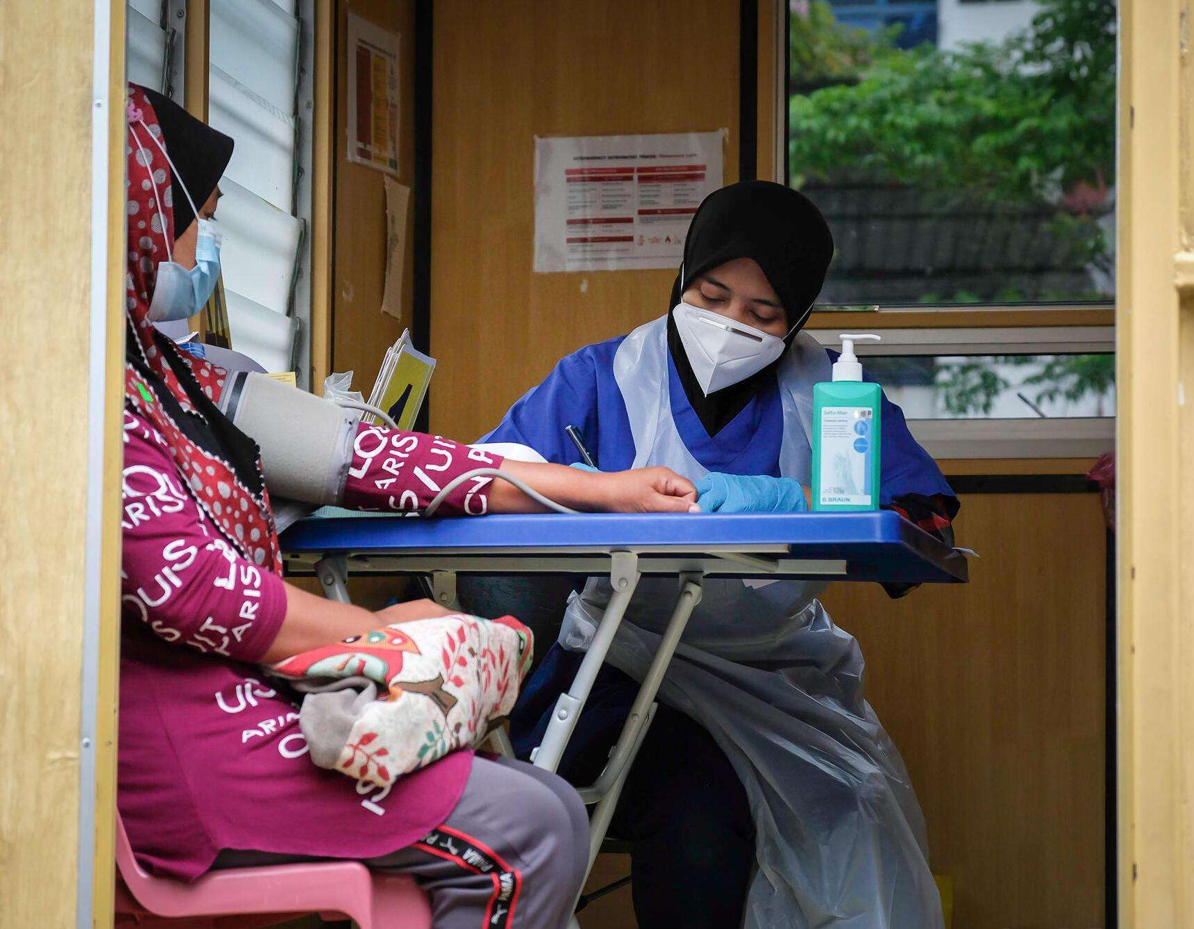 MSF triage nurse, Izyan, examines a patient in Malaysia.