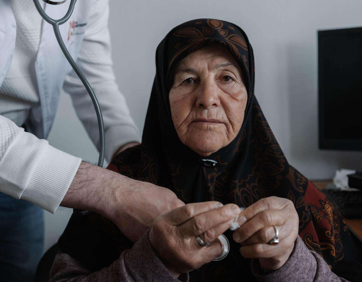 An elderly displaced woman in Lebanon receives care at an MSF clinic.