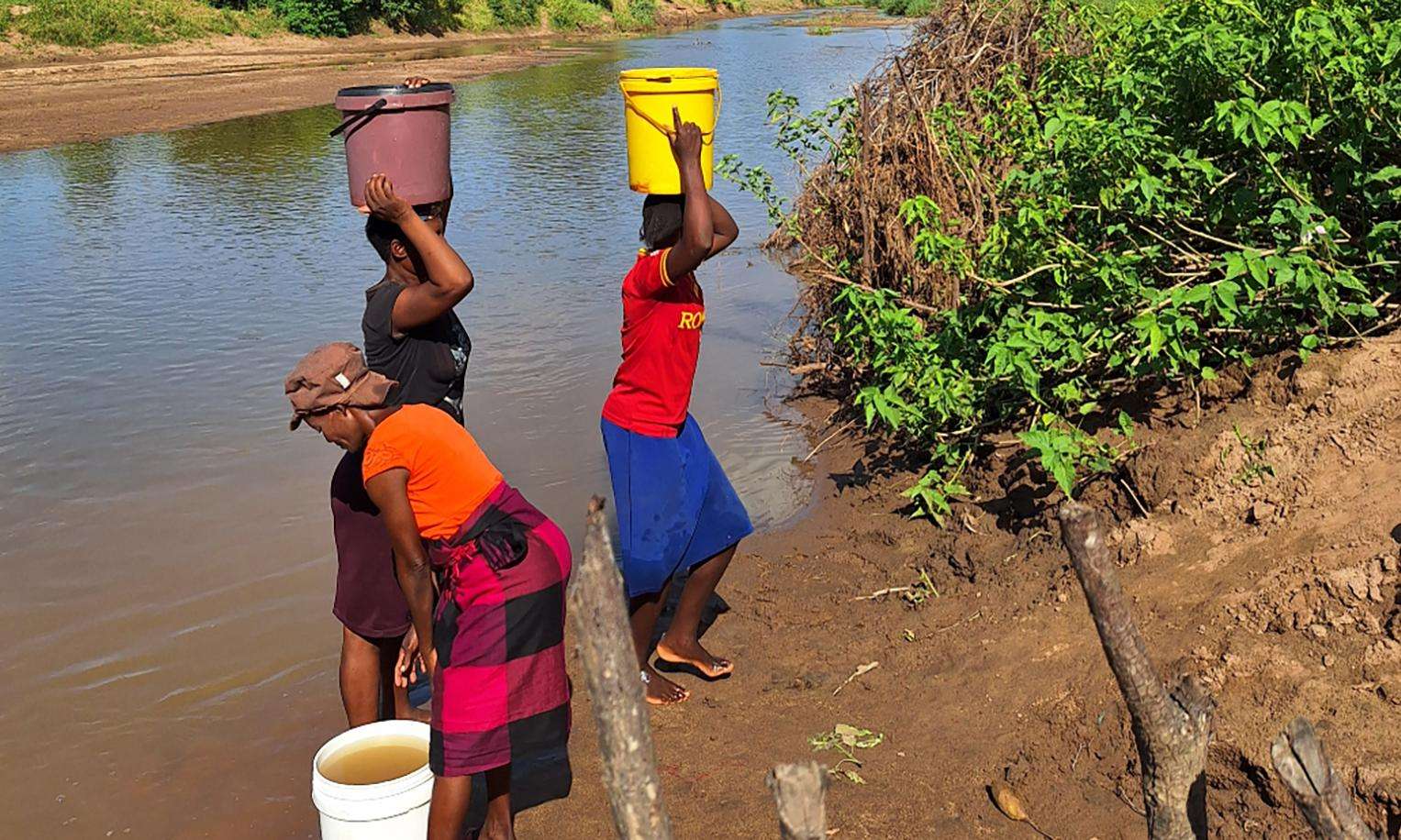 Women fetch wate from a river in Zimbabwe.