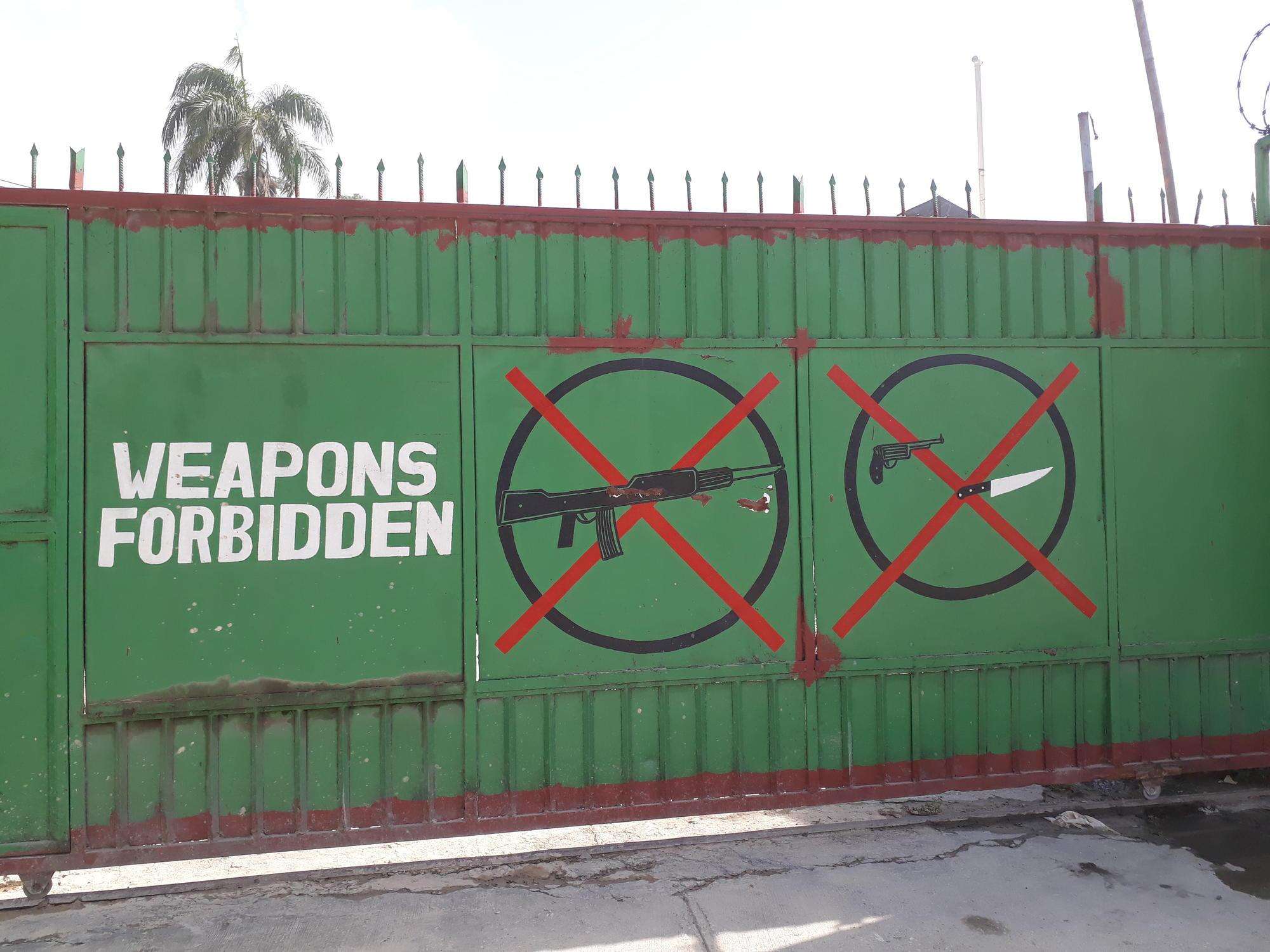 The gates of the Martissant Center in Port-au-Prince, Haiti, say "Weapons Forbidden".