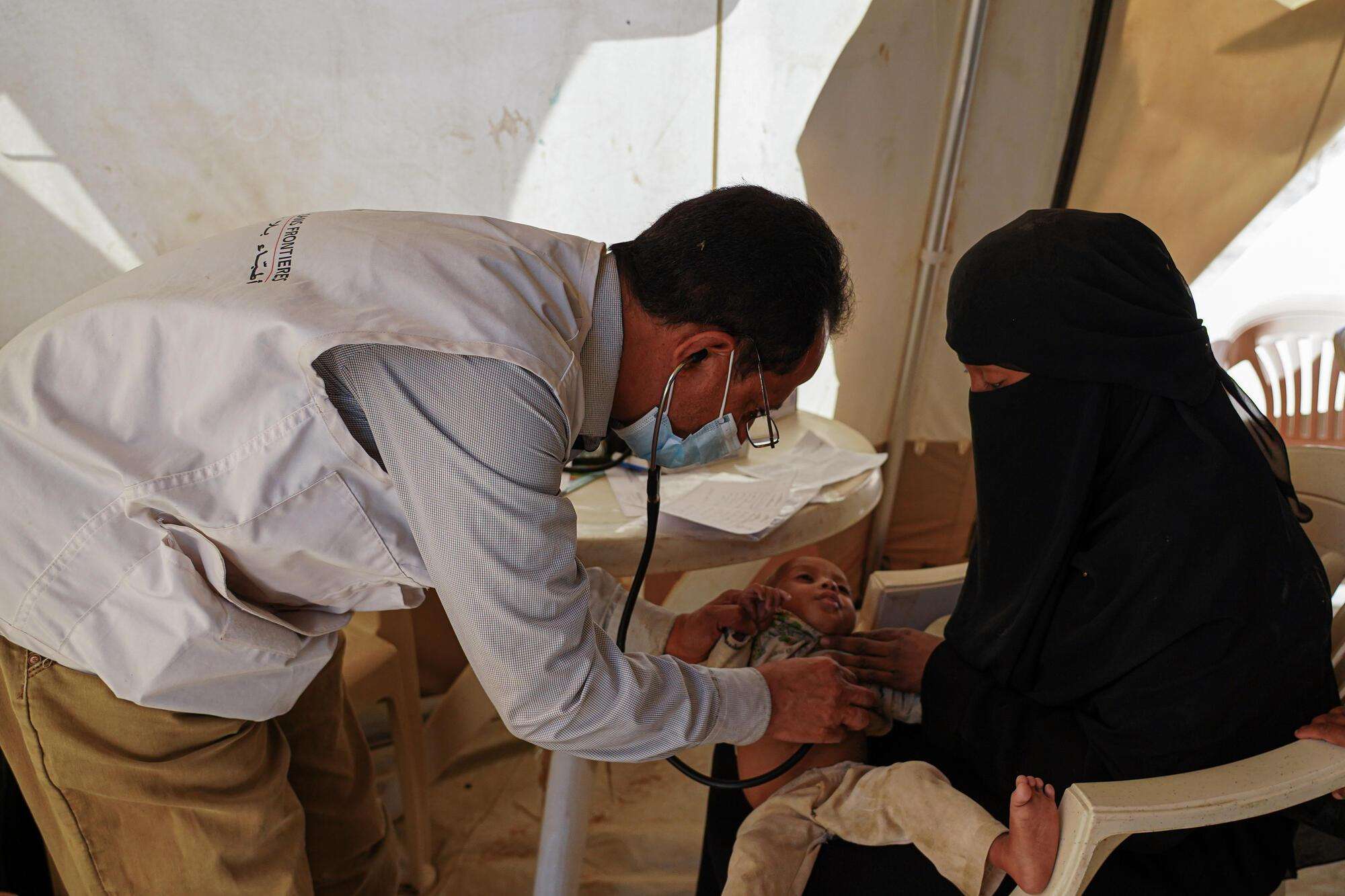 MSF doctor Abdul Malik examining one-year-old baby