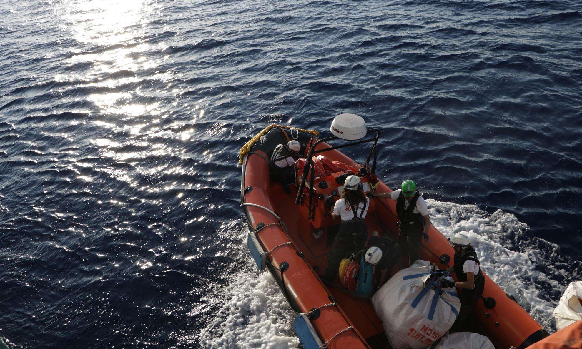 MSF search and rescue teams on an orange rescue boat respond to a migrant ship in distress in the Mediterranean sea 
