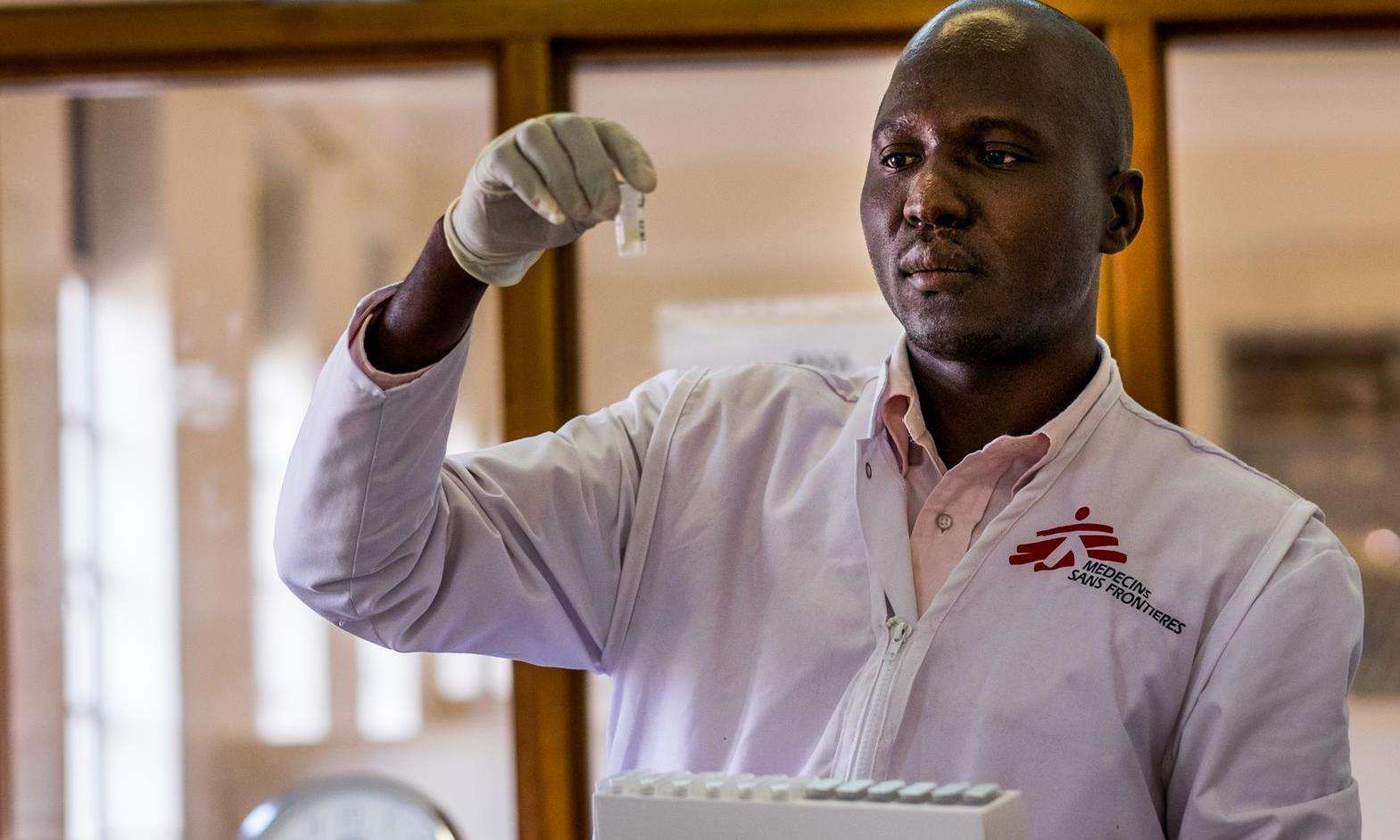 An MSF doctor holds up a test tube he is examining in a lab in Arua, Uganda.