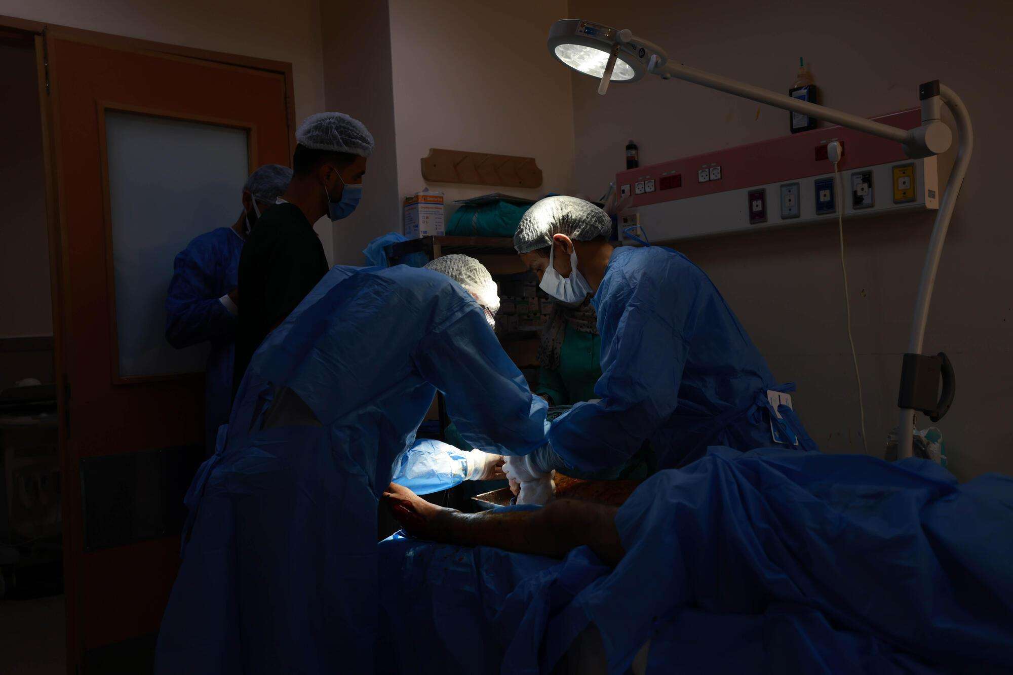 Surgeons operate under a spotlight at Al Aqsa hospital in Gaza.