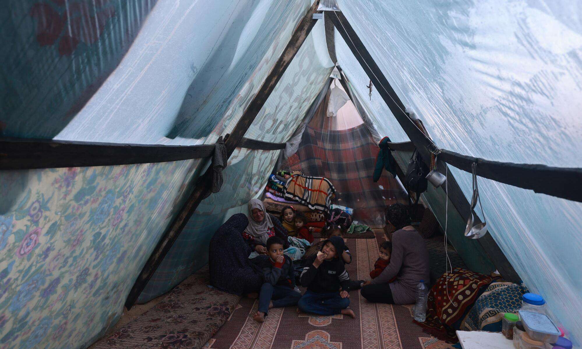 A displaced Palestinian family inside their tent in the southern Gaza town of Rafah’s Al-Shaboura neighborhood.