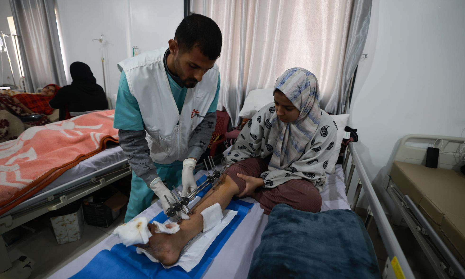 An MSF staff member treats a patient at Rafah Indonesian Field Hospital in Gaza