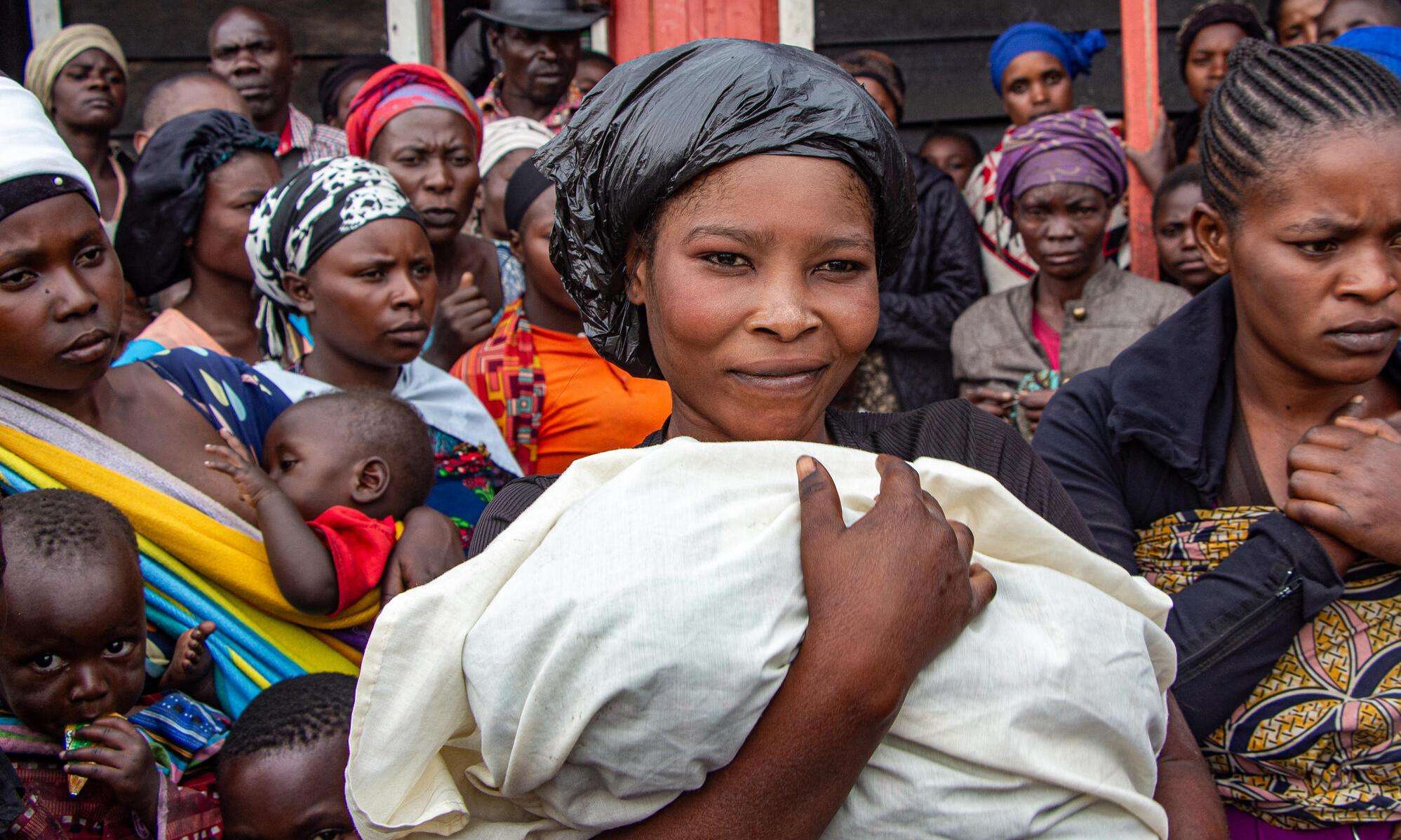 A Congolese woman holding a baby wrapped in a blanket in DR Congo.