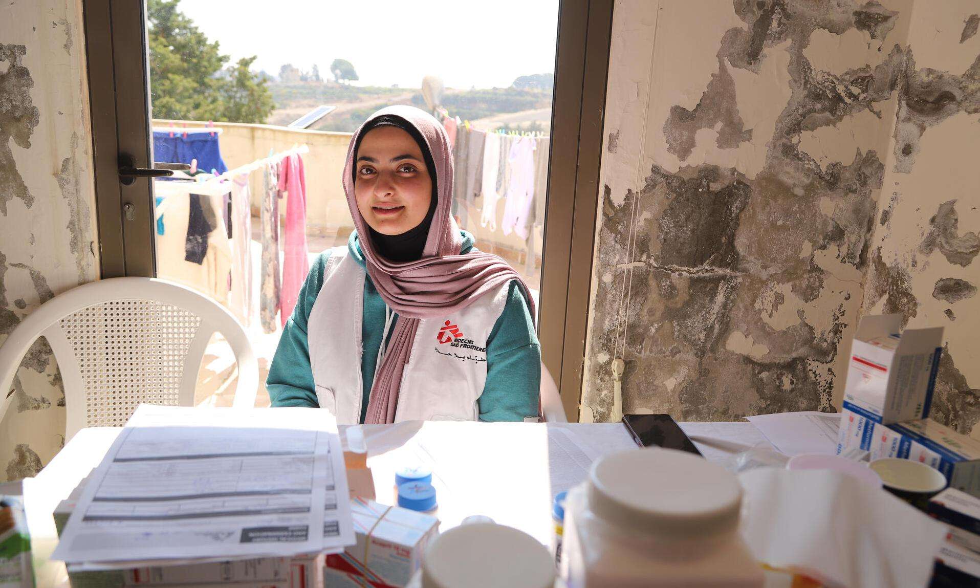 An MSF staff member through the window of a shelter for IDPs in Saida, South Lebanon