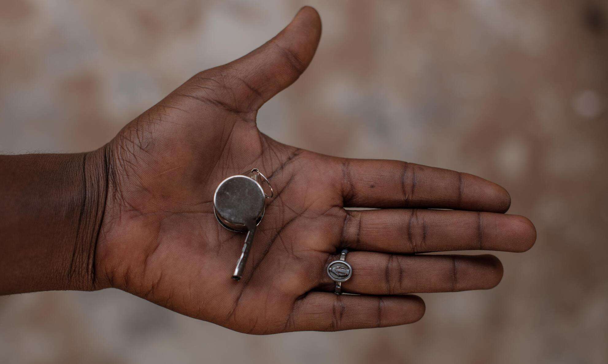 An open hand holding a whistle for protection from sexual violence in Nigeria.