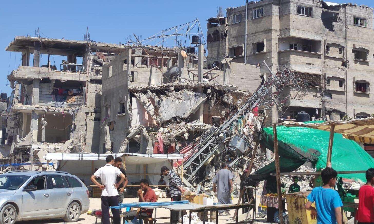 Palestinians in Rafah look at a destroyed building. 
