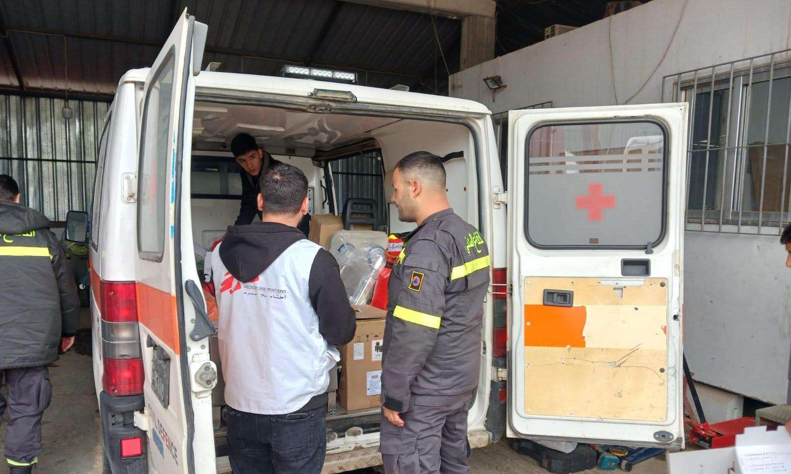 An MSF staff stands next to a Lebanese civil defense worker in front of an ambulance in Lebanon. 