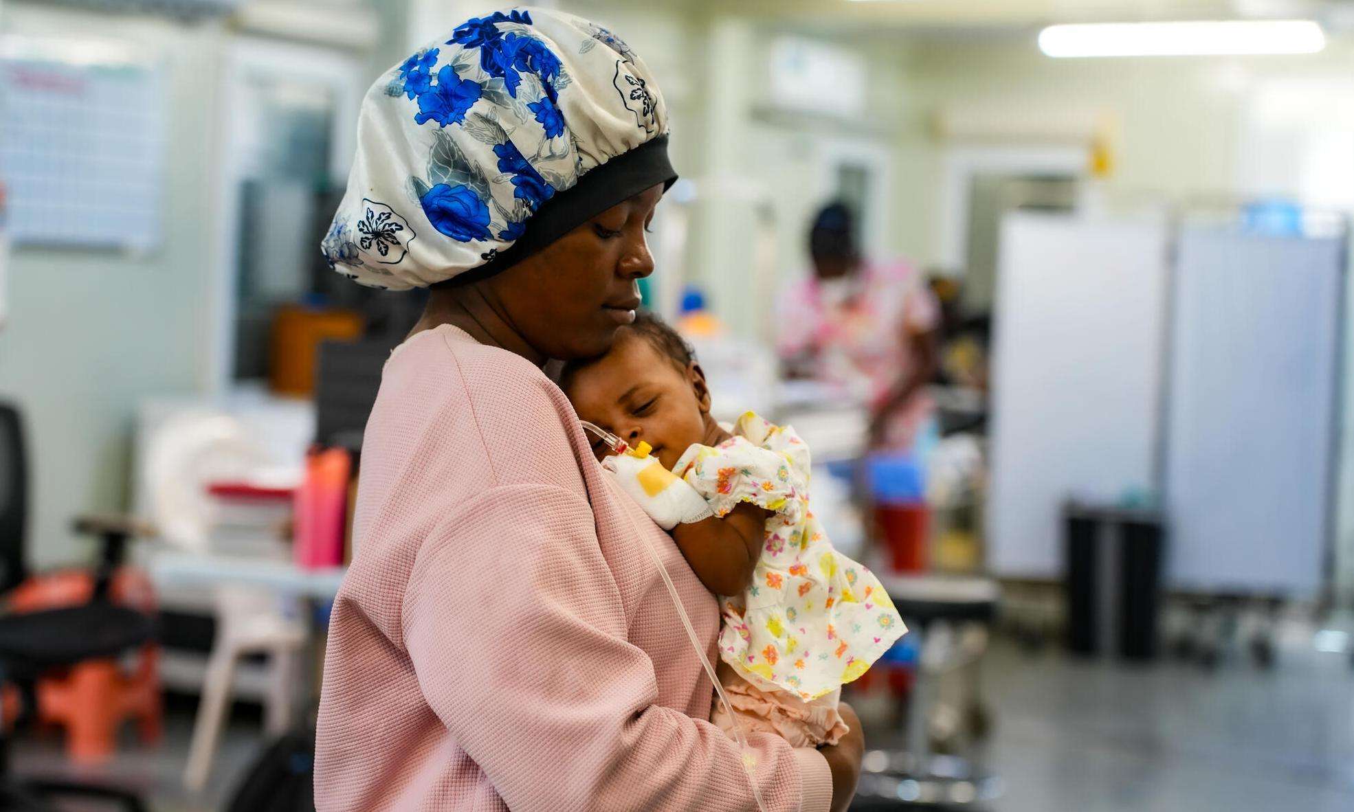 A mother holds her baby in Cité Soleil, Haiti.