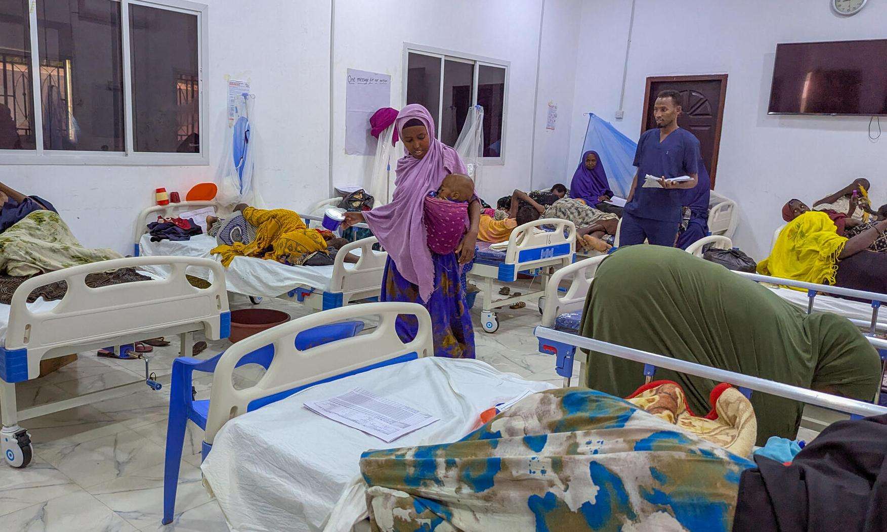 Patients lying in beds in a crowded hospital ward in Somalia. 