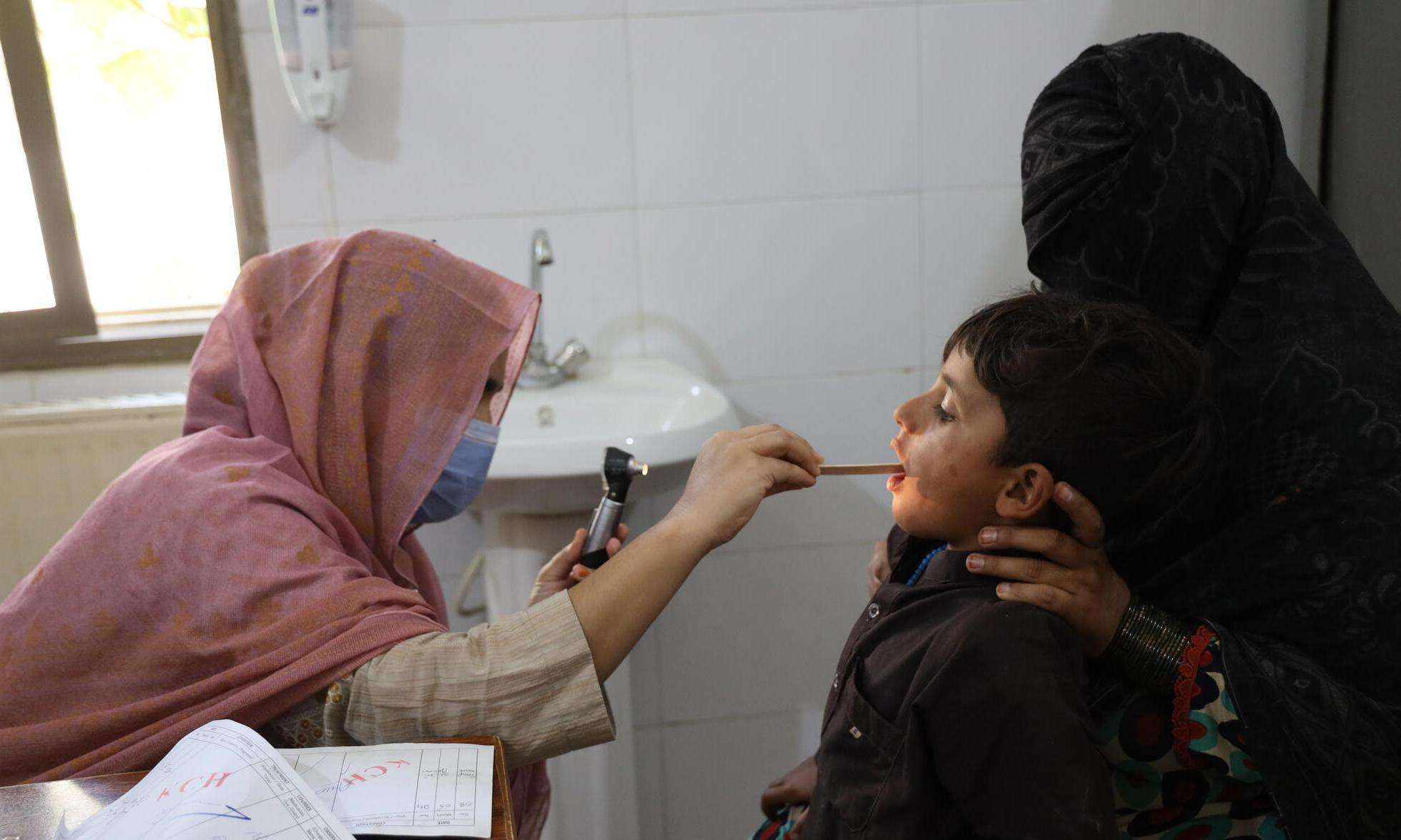 A doctor performs a checkup of a child in Pakistan. 