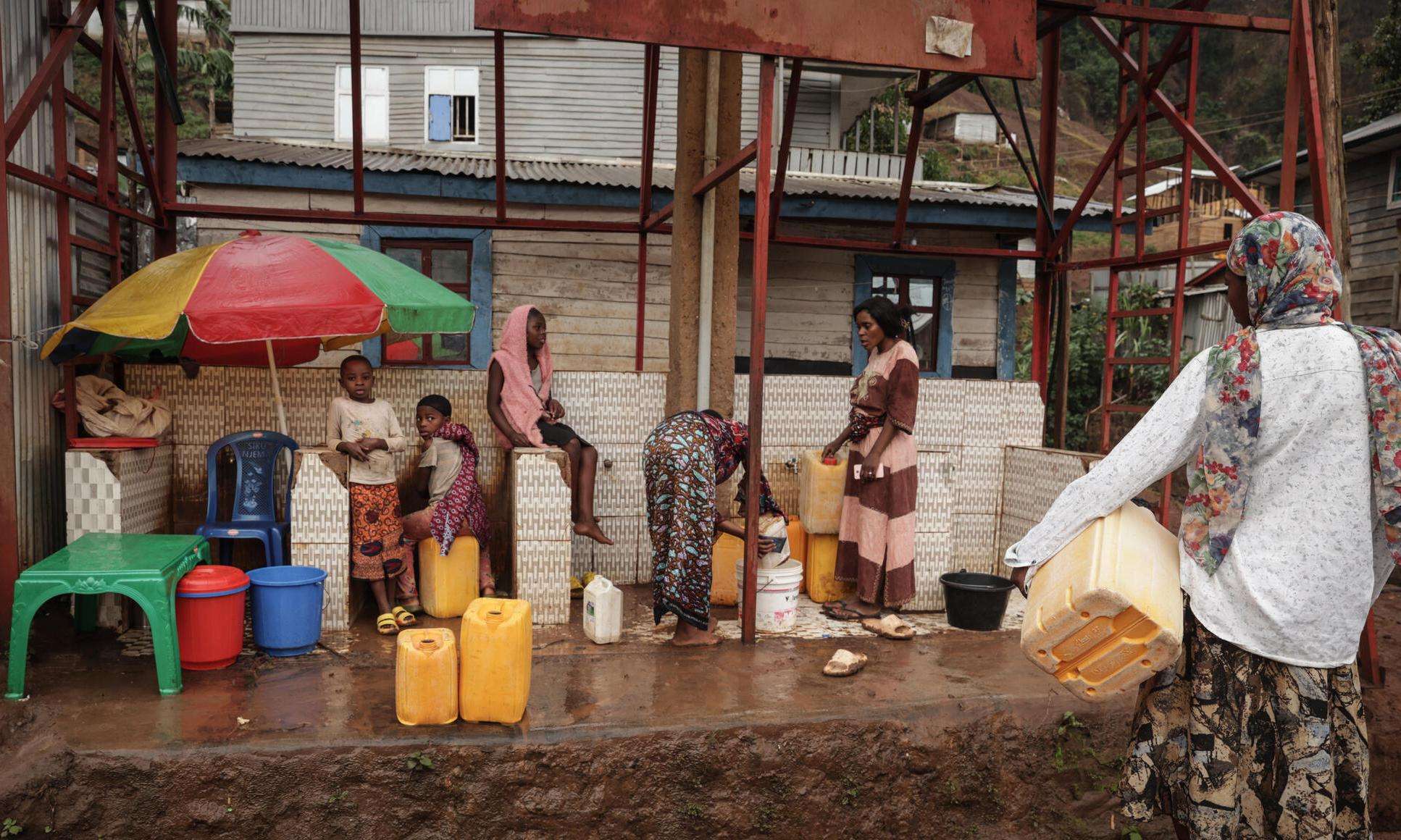People line up to collect drinking water in DR Congo. 