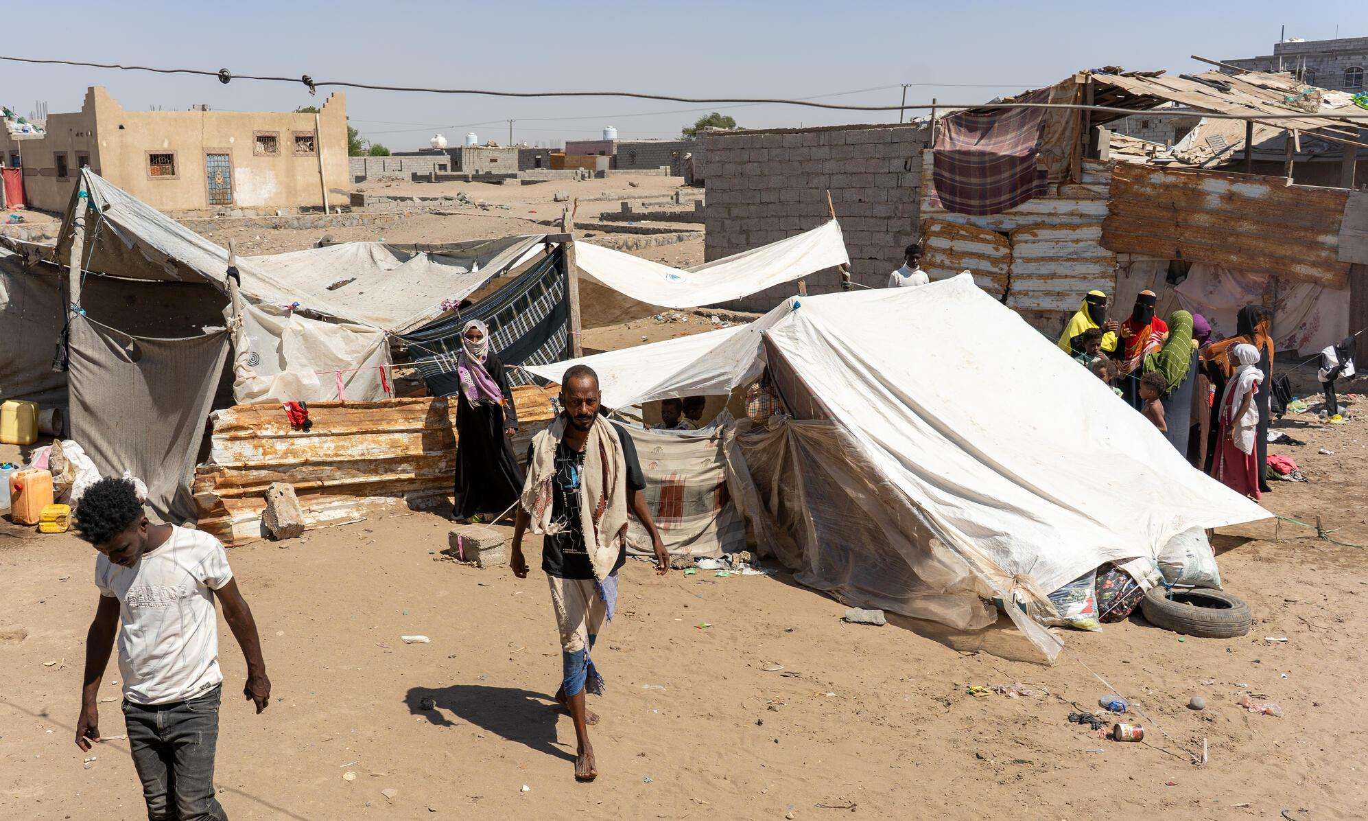 People walk in a displacement camp in Yemen. 