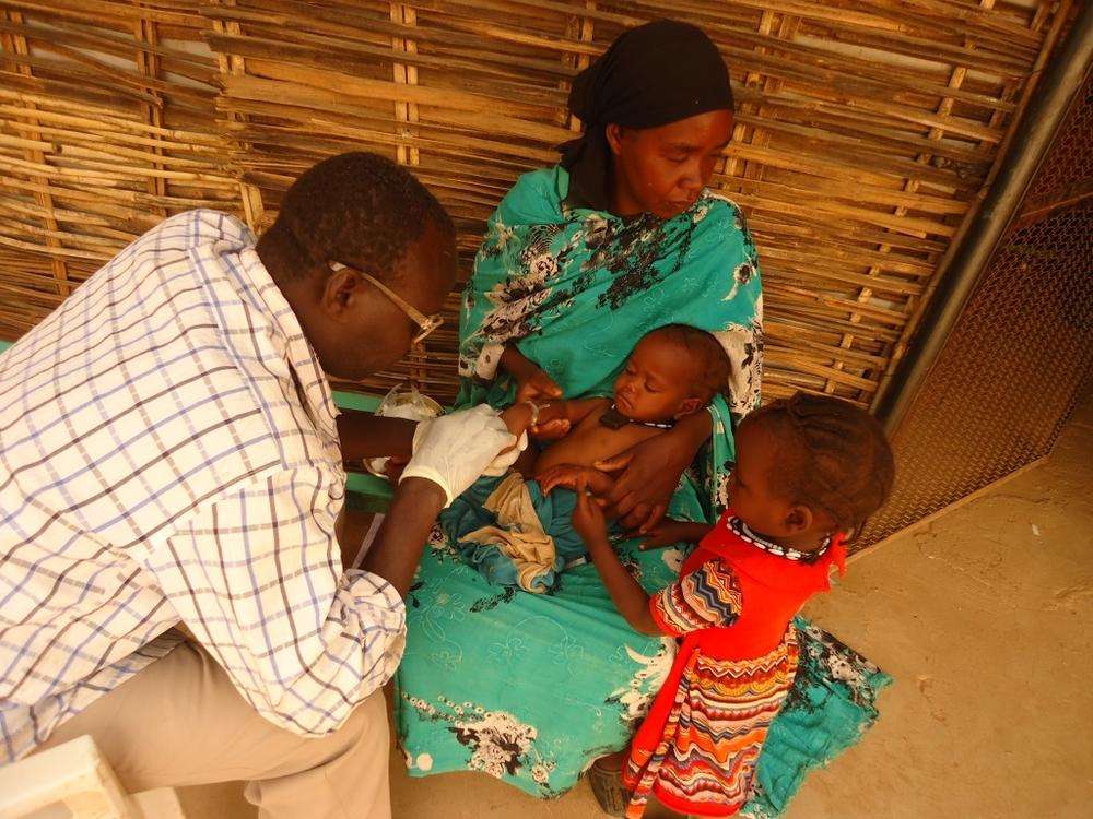A child is examined by a nurse in the small village of Sortoni, Darfur.