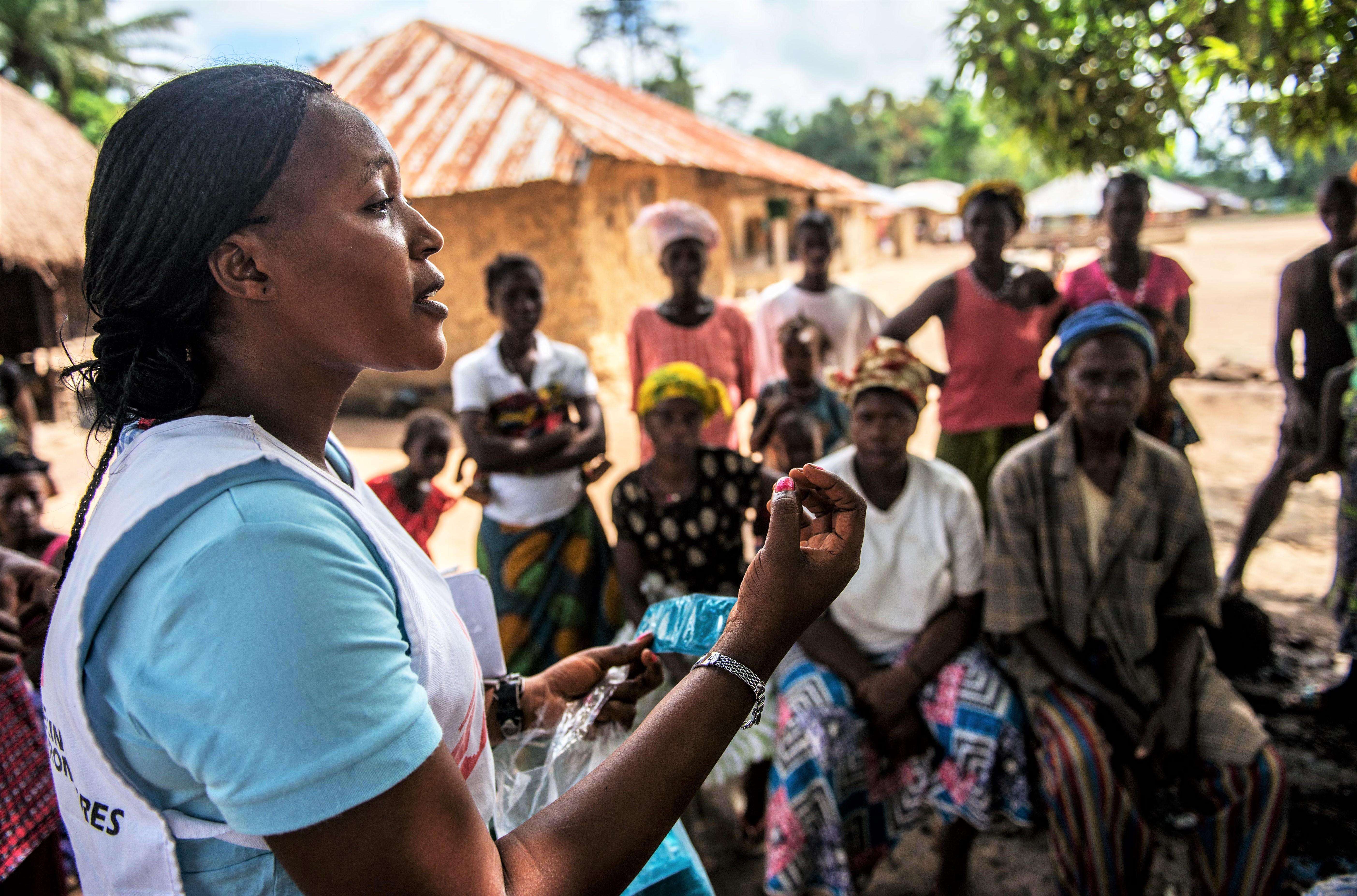Health promoter, Emma Kamara, talks to villagers about health issues during a MSF outreach mission to treat survivors of Ebola. 
