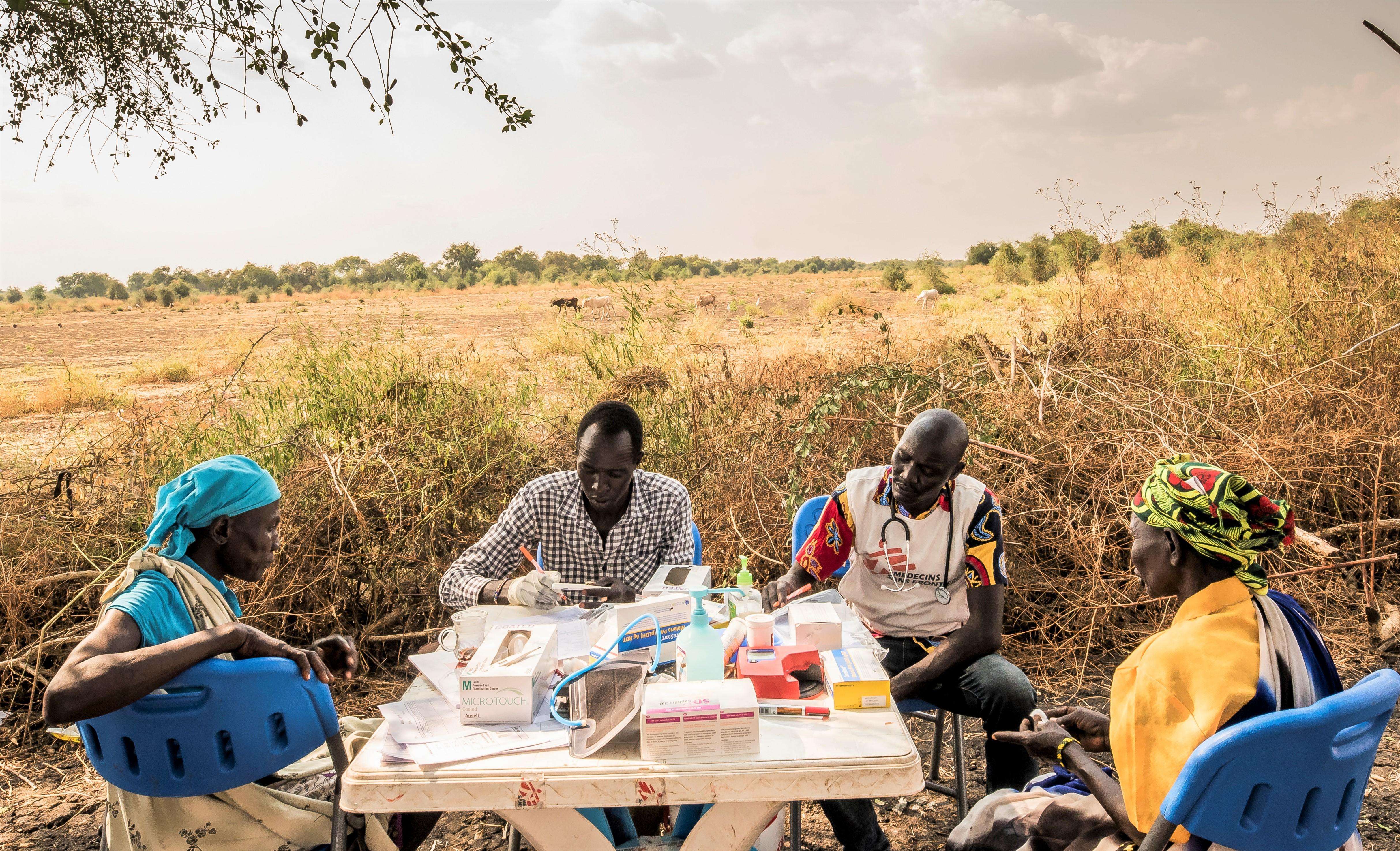 In the shade of a tree, mobile medical staff provide health consultations. Once per week, MSF sets up its medical clinic under trees in the village of Kier, on the banks of the Pibor River.