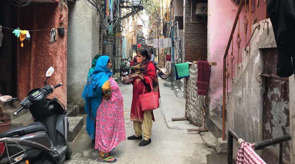 Seema Rani, an ASHA volunteer and MSF community health worker, talks to a Jahangirpuri resident. 