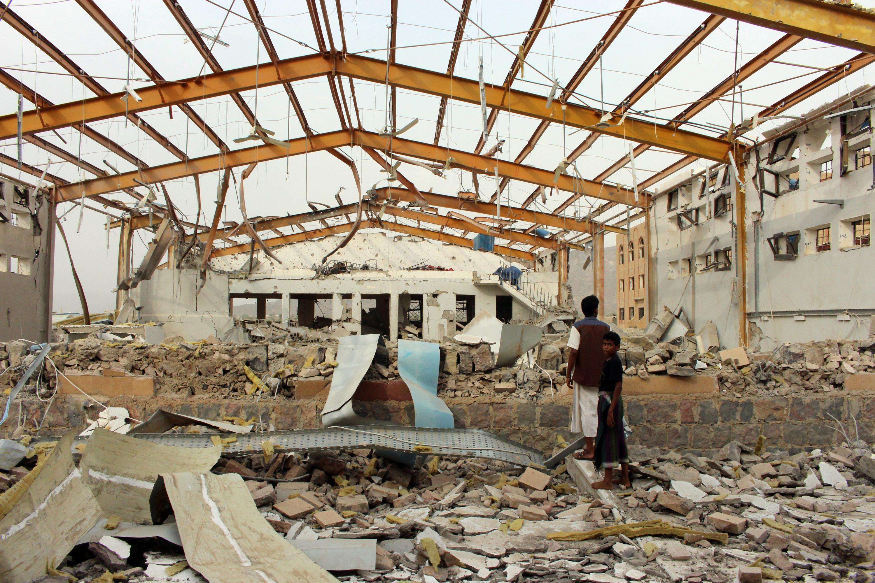 Yemenis survey the damage caused by a Saudi-led airstrike on an MSF-supported cholera treatment center in Yemen’s Abs region in June. No staff or patients were killed or injured in the attack.