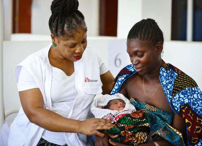 Furaha Walumpupu, midwife activity manager, with a mother and her child in the maternity ward in Liwale.