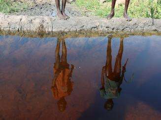 Reflection of two people on the surface of water in South Sudan