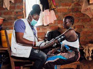 In an MSF mobile clinic, Bumbeh village, Kenema district, Sierra Leone, Midwife Sia Kallon, takes the blood pressure of 35-year old Hawa Lansana, who is 14 weeks pregnant.