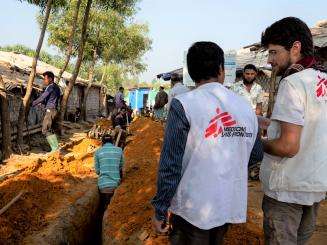 Paolo and Chandon, MSF water and sanitation logisticians, in front of the excavations for the sediment of pipes carrying water in camp 1 in Kutupalong and Balukali areas.