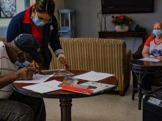 Nursing home staff working with residents on a project 