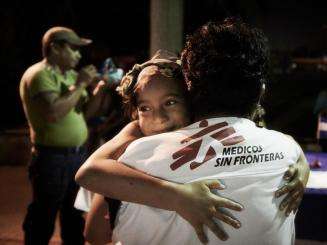 MSF social worker hugs a migrant girl