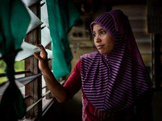 A Rohingya refugee looks out of her window in Malaysia